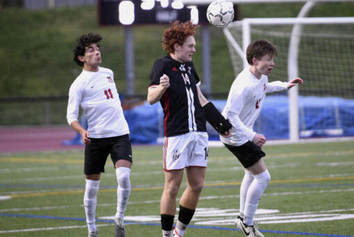 Union's Caleb Putney, center, goes up for a header between Camas' Shiven Friedeman, left, and Travis O'Hara during a 4A Greater St. Helens League boys soccer match on Thursday, March 28, 2024, at Union High School.
