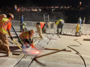 Workers cut away an old expansion joint on Interstate 5 in Seattle, during 2022.