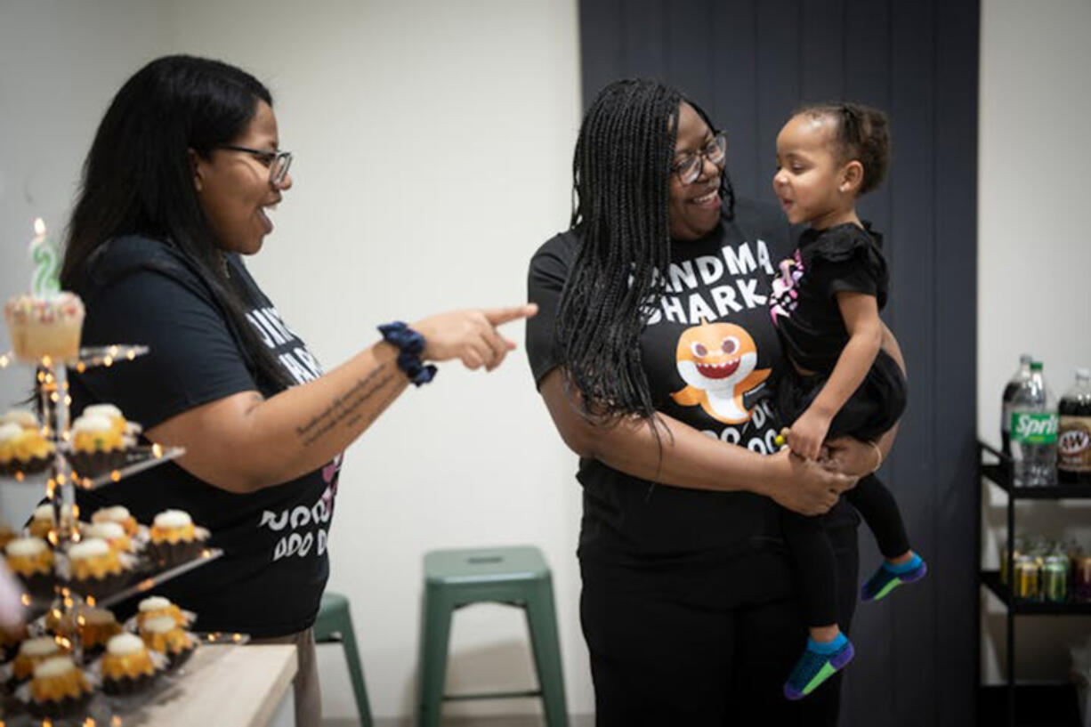 Taylor Richardson, left, smiles as her mother Ruth Richardson, executive director of Planned Parenthood North Central States, center, holds her granddaughter, Trinity, at the little girl&rsquo;s birthday party on Feb. 3. A former Minnesota legislator, Ruth Richardson says she sees health equity as central to the future of Planned Parenthood.