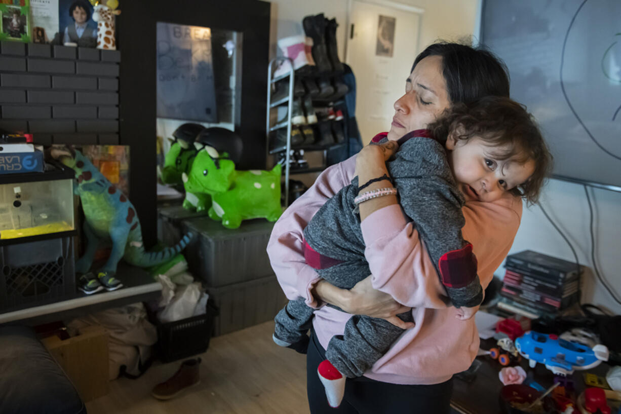 Monica Zazueta, 37, of Vancouver comforts her toddler, Rufio,1, after he took a tumble on the floor at their home Feb. 15. Zazueta and her family, who experienced homelessness a few years ago, are now housed and paying rent of almost $1,900 a month. She fears the family will become homeless again. &ldquo;We&rsquo;re surviving through love,&rdquo; she said. &ldquo;Our kiddos don&rsquo;t deserve this kind of life.