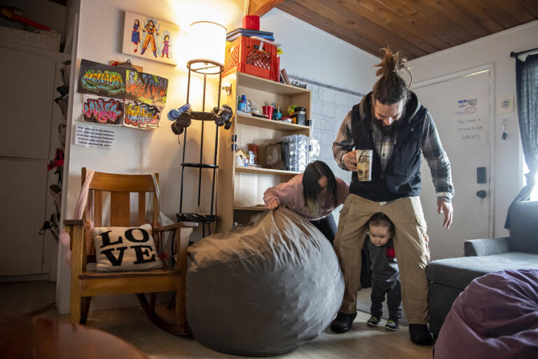 Monica Zazueta, from left, joins Ryan Tabor and Rufio Tabor, 1, as they enjoy some playtime in their Vancouver home Feb. 15.