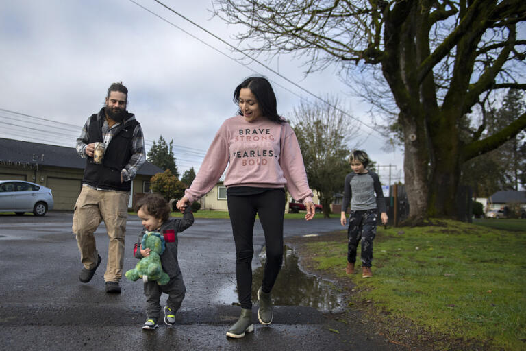 Ryan Tabor, 38, from left, keeps in step with Rufio Zazueta, 1, Monica Zazueta, 37, and Aries Zazueta, 9, during a family walk in their Vancouver neighbor-hood Feb. 15.