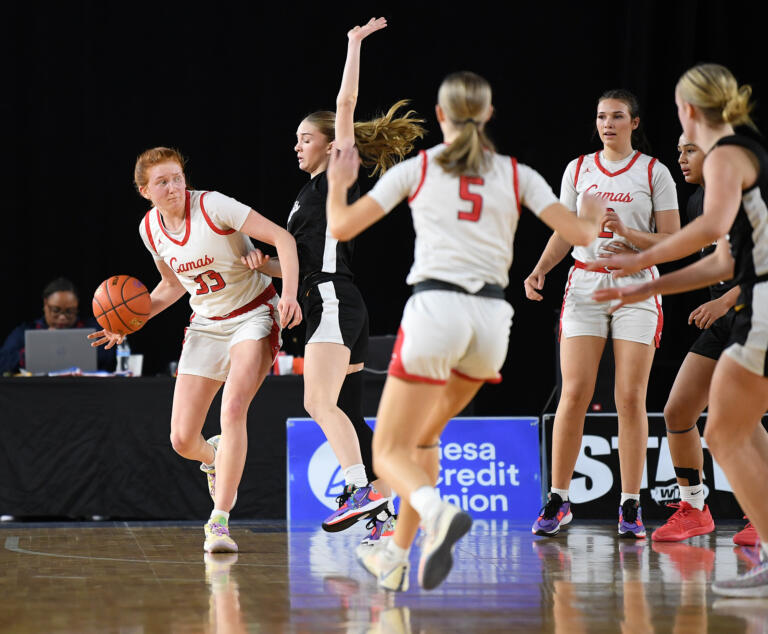Camas senior Addison Harris, left, looks for an open teammate Friday, March 1, 2024, during the Papermakers’ 60-48 win against Sumner in a WIAA 4A State Basketball semifinal game at the Tacoma Dome.