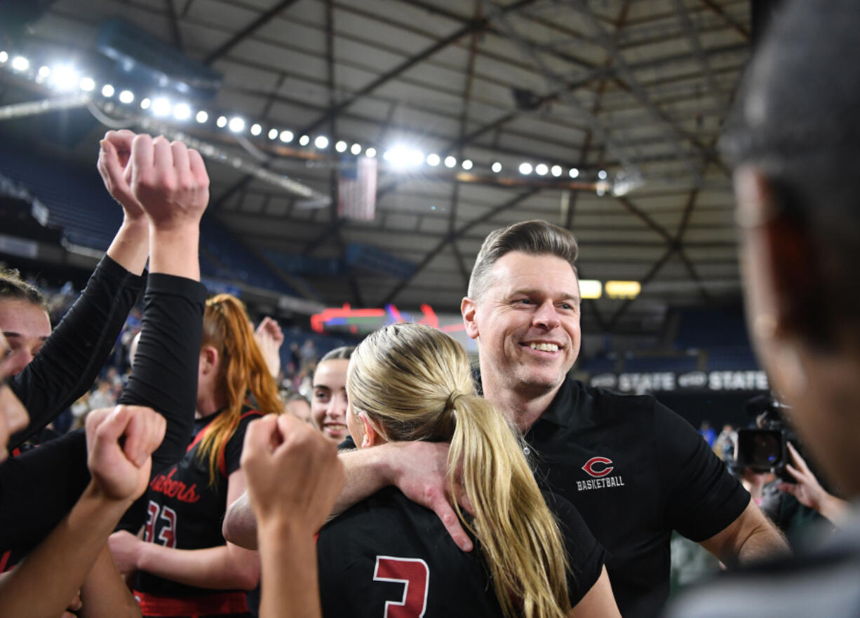 Camas head girls basketball coach Scott Thompson, right, hugs Camas senior Riley Sanz (3) on Saturday, March 2, 2024, after the Papermakers&Ccedil;&fnof;&Ugrave; 57-41 win against Gonzaga Prep in the 4A WIAA State Basketball championship game at the Tacoma Dome.
