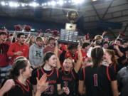 Camas senior Riley Sanz (3) lifts the state championship trophy in front of the Camas student section Saturday, March 2, 2024, after the Papermakers’ 57-41 win against Gonzaga Prep in the 4A WIAA State Basketball championship game at the Tacoma Dome.