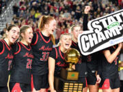 The Camas girls basketball team celebrates with the state trophy Saturday, March 2, 2024, after the Papermakers’ 57-41 win against Gonzaga Prep in the 4A WIAA State Basketball championship game at the Tacoma Dome.