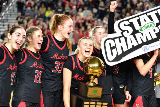 The Camas girls basketball team celebrates with the state trophy Saturday, March 2, 2024, after the Papermakers’ 57-41 win against Gonzaga Prep in the 4A WIAA State Basketball championship game at the Tacoma Dome. (Taylor Balkom/The Columbian)