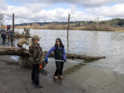 Nancy Erickson of Tacoma, left, joins Courtney Liu, also of Tacoma, for a one-day chance for smelt dipping on the Cowlitz River on Tuesday afternoon. At top, a young fisherman gets a hands-on experience with a slippery smelt.