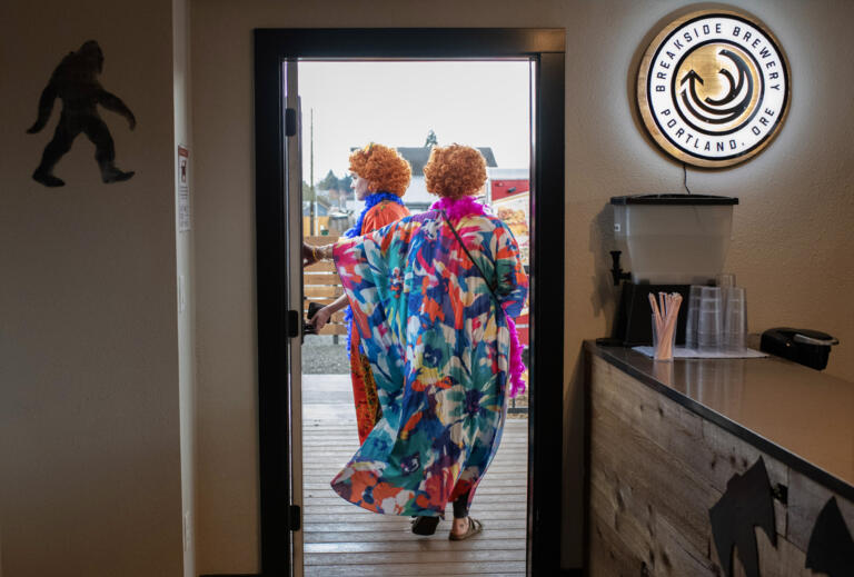 Alexxa Brumley, cq, of Battle Ground, left, joins her mom, Kendra Brumley, who is visiting from Arizona, with their colorful caftans flowing as they make their way outside at Tukes Taphouse during the Mrs. Roper Pub Crawl on Saturday evening, March 23, 2024.