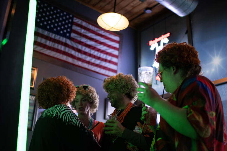 An American flag is seen overhead as Cassandra Blakeslee of La Center, right, joins the fun at Playmakers Sports Bar &amp; Grill during the Mrs. Roper Pub Crawl on Saturday evening, March 23, 2024.