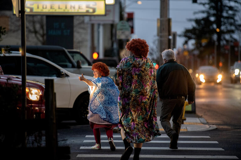 Participants in the Mrs. Roper Pub Crawl greet a motorist as they stroll towards their next location in downtown Battle Ground on Saturday evening, March 23, 2024.