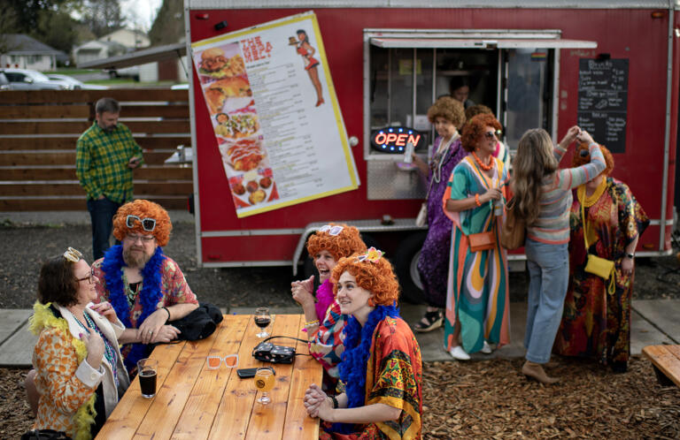 Participants stop by Tukes Taphouse for food, drinks and a wig adjustment during the Mrs. Roper Pub Crawl in downtown Battle Ground on Saturday evening, March 23, 2024.