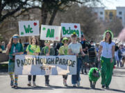 Participants in the annual Paddy Hough Parade greet spectators along the route on Friday afternoon, March 15, 2024.