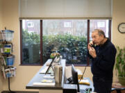 Longtime volunteer John LaPointe answers the front desk phone Monday at the NAMI Southwest Washington office in Vancouver.