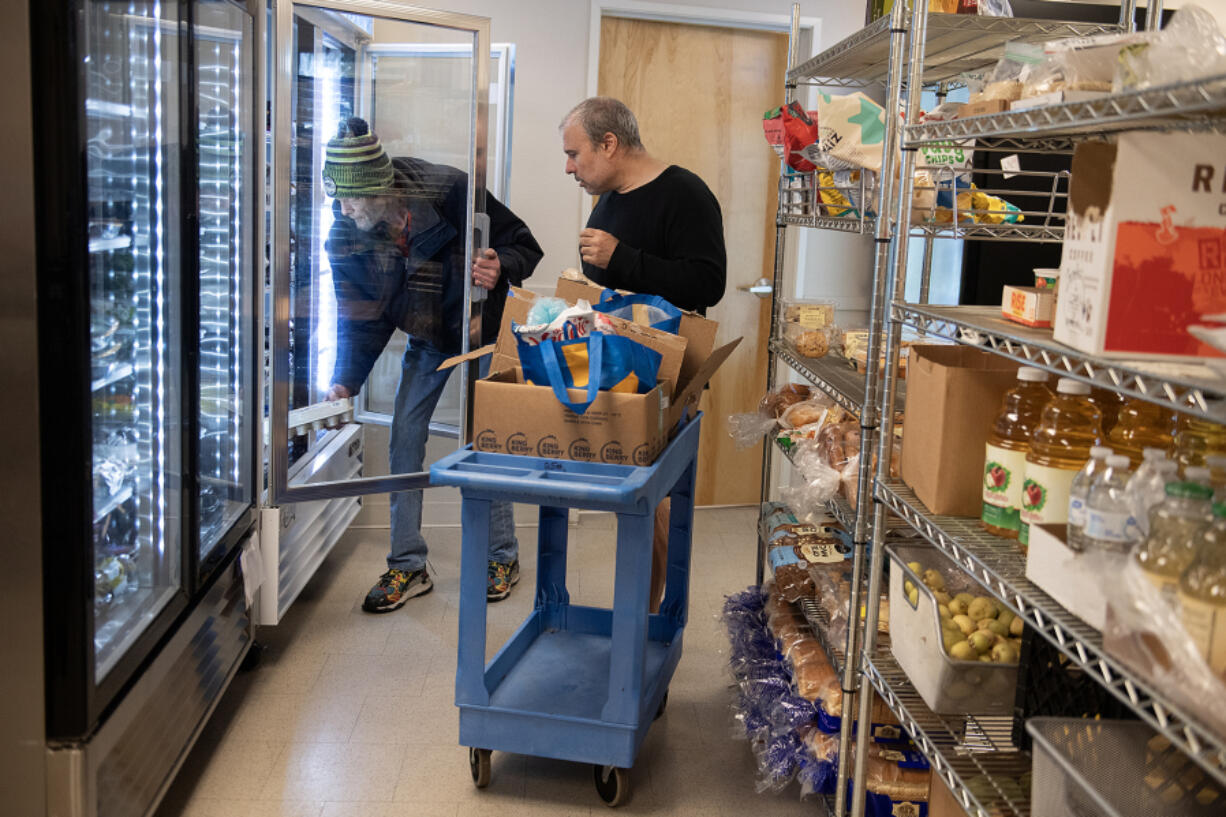 Ron Minarik, left, gets a hand with his groceries from volunteer John Dibella while shopping at Martha&rsquo;s Pantry on Wednesday morning. The pantry, which is hosted by the Metropolitan Community Church of the Gentle Shepherd, has been serving Vancouver since 1984 and is celebrating its 40th anniversary.