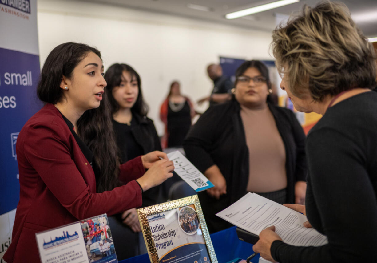 Hispanic Metropolitan Chamber senior business developer Kimberly Quiroz, from left, student representative and Franklin High School sophomore Brianna Quiroz, and scholarship coordinator Norma Palacios talk to attendee Diane Calderon on Friday, during a small business event at Cascade Park Library in Vancouver.
