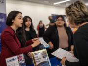 Hispanic Metropolitan Chamber senior business developer Kimberly Quiroz, from left, student representative and Franklin High School sophomore Brianna Quiroz, and scholarship coordinator Norma Palacios talk to attendee Diane Calderon on Friday, during a small business event at Cascade Park Library in Vancouver.