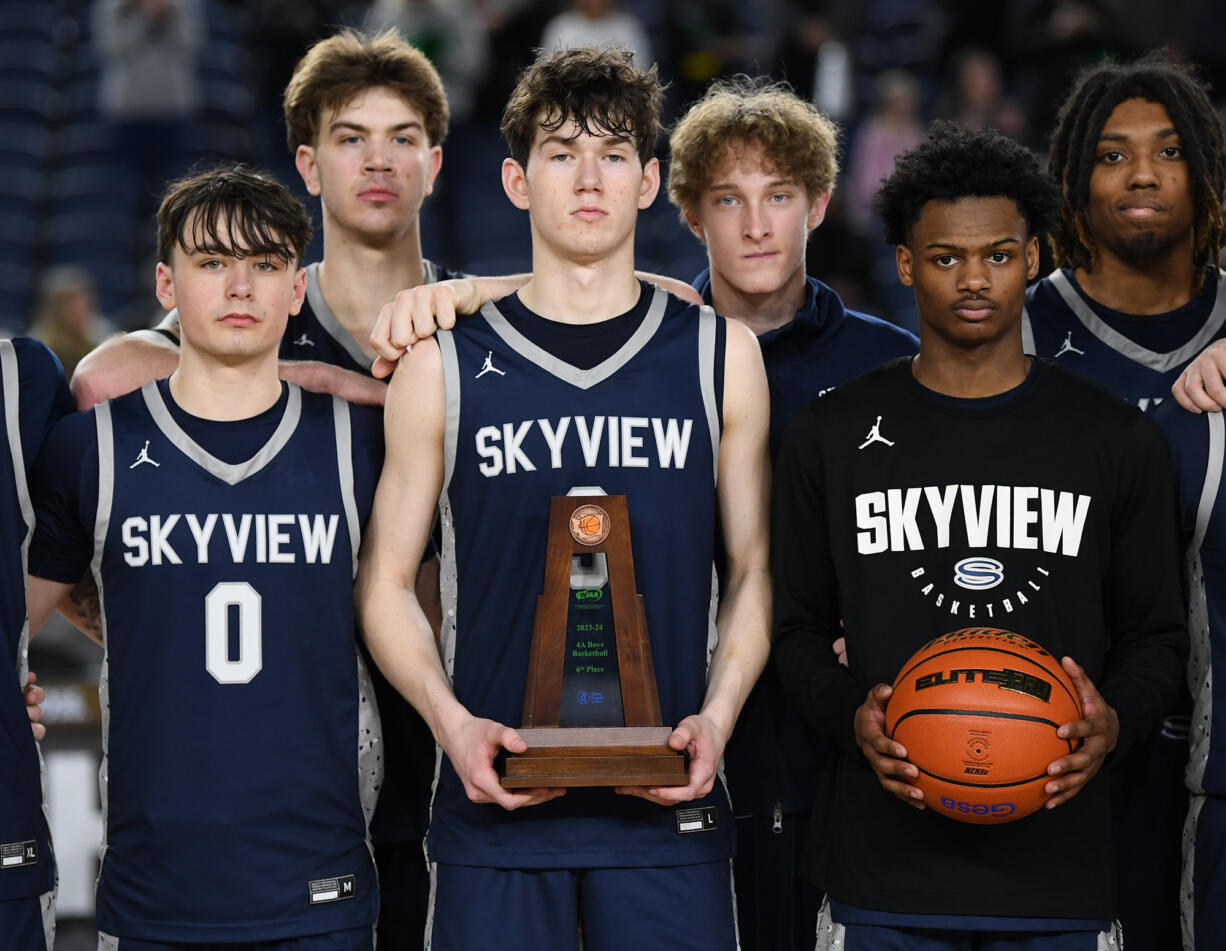 Skyview players stand for a photo with their sixth place trophy Saturday, March 2, 2024, following the Storm’s 69-47 loss to Kentwood in a WIAA State Basketball consolation game at the Tacoma Dome. The 2023-24 Storm matched the school’s highest ever finish from 2018.
