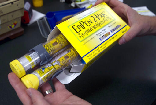 FILE - In this July 8, 2016, file photo, a pharmacist holds a package of EpiPen epinephrine auto-injectors, a Mylan product, in Sacramento, Calif. Mylan N.V. reports financial results on Wednesday, Feb. 28, 2018.