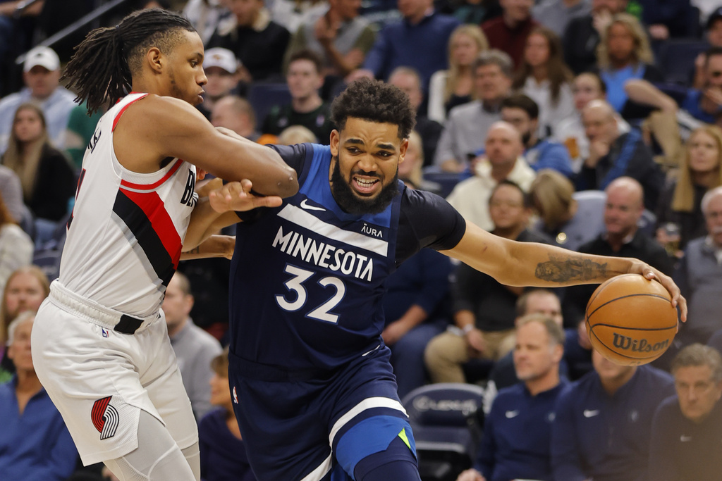 Minnesota Timberwolves forward Karl-Anthony Towns (32) goes to the basket around Portland Trail Blazers forward Jabari Walker, left, in the first quarter of an NBA basketball game Monday, March 4, 2024, in Minneapolis.