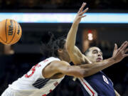 Saint Mary's forward Mason Forbes (25) and Gonzaga guard Ryan Nembhard (0) go after the ball during the first half of an NCAA college basketball game for the championship of the West Coast Conference men's tournament Tuesday, March 12, 2024, in Las Vegas.