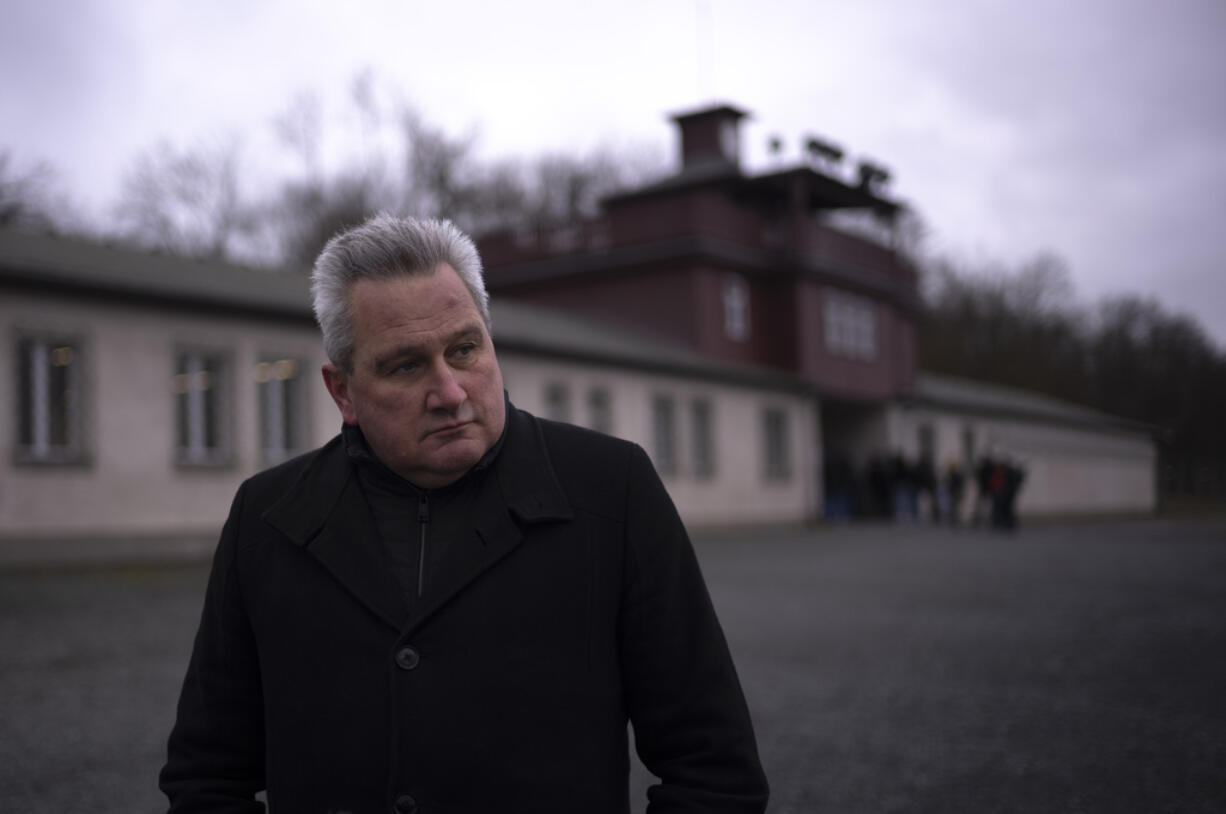 The head of the Buchenwald Memorial, Jens-Christian Wagner poses for a photo near the main gate of the former Nazi concentration camp Buchenwald in Weimar, Germany, Wednesday, Jan. 31, 2024. Attacks on the site  have stepped up massively in recent months: Wagner says this is because of the "revisionist, antisemitic and racist slogans" promoted by the far-right Alternative for Germany, or AfD party.