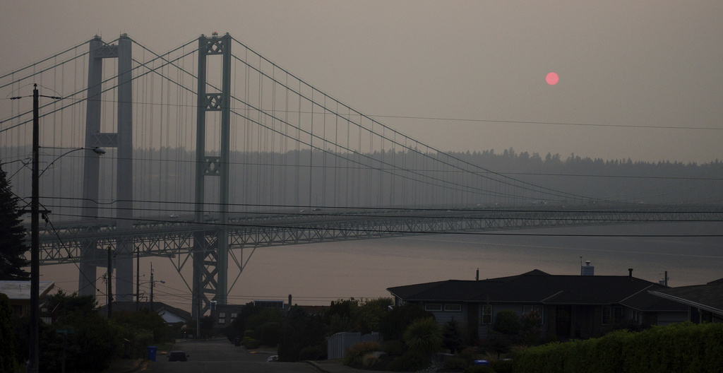 FILE - The sun sets through smoky air behind the Narrows Bridge in Tacoma, Wash., on Aug. 19, 2018. A coroner's investigation into the death of a man in Los Angeles in February 2024 revealed that he was a suspect in a 2008 Washington state child rape who was believed to have jumped to his death from a bridge on Puget Sound years ago, authorities said. A witness reported seeing the man jump from the Tacoma Narrows Bridge on March 29, 2009. (AP Photo/Ted S.