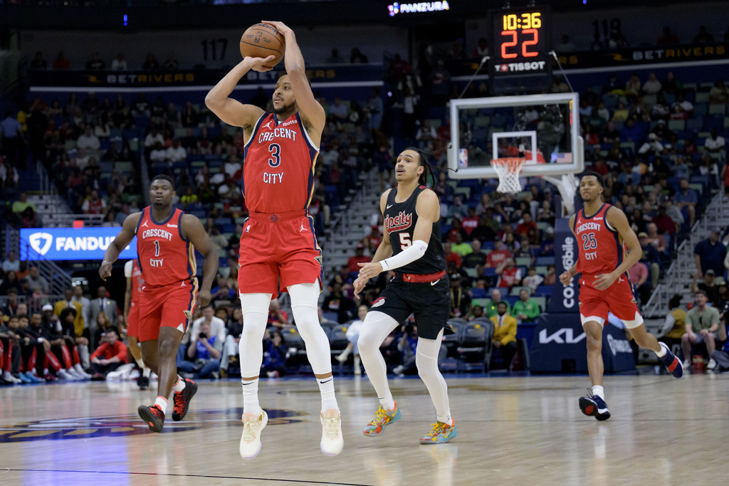 New Orleans Pelicans guard CJ McCollum (3) shoots a wide open 3-point basket after making a steal during the first half of an NBA basketball game against the Portland Trail Blazers including guard Dalano Banton (5) in New Orleans, Saturday, March 16, 2024.
