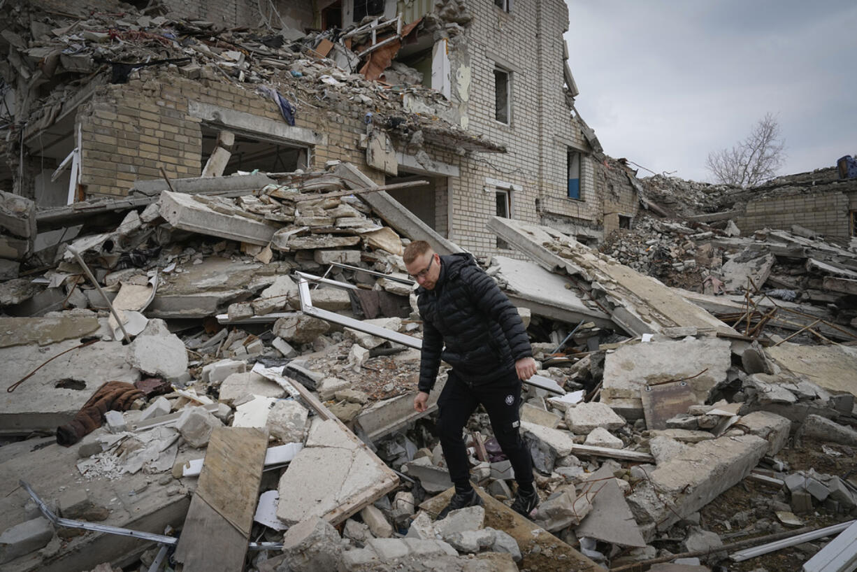 Local resident Yevhen, 34, looks for his belongings at his home in an apartment house damaged in 2022 heavy battles with the Russian troops in Izium, Kharkiv region, Ukraine, Sunday, March 17, 2024.