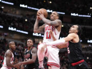 Chicago Bulls' DeMar DeRozan (11) drives to the basket and is fouled by Portland Trail Blazers' Dalano Banton, right, during the first half of an NBA basketball game Monday, March 18, 2024, in Chicago.