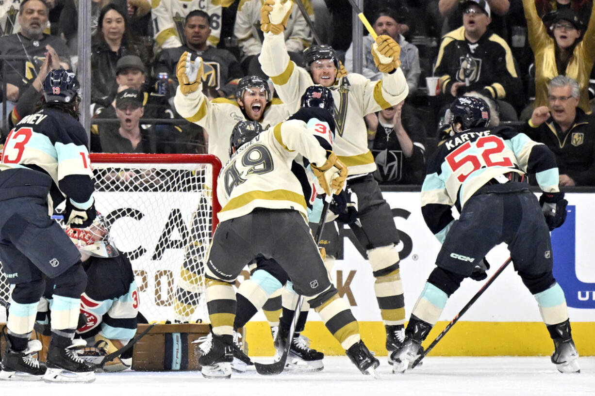 Vegas Golden Knights right wing Jonathan Marchessault, rear, and center Jack Eichel (9) celebrate after Eichel scored against the Seattle Kraken during the first period of an NHL hockey game Thursday, March 21, 2024, in Las Vegas.