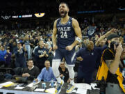 Yale guard Yassine Gharram (24) stands on a table after celebrating with fans after Yale upset Auburn in a first-round college basketball game in the NCAA Tournament in Spokane, Wash., Friday, March 22, 2024. (AP Photo/Ted S.