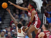 Washington State forward Isaac Jones (13) blocks the shot of Iowa State guard Keshon Gilbert (10) in the first half of a second-round college basketball game in the NCAA Tournament, Saturday, March 23, 2024, in Omaha, Neb.
