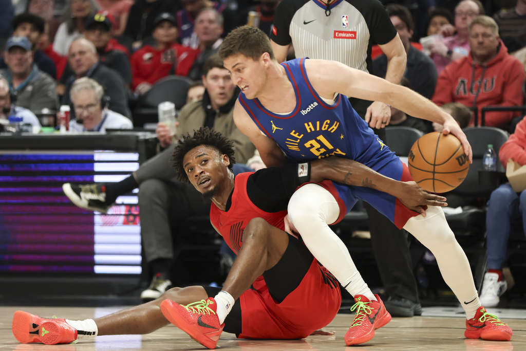 Portland Trail Blazers guard Ashton Hagans, left, and Denver Nuggets guard Collin Gillespie (21) scramble for a loose ball during the second half of an NBA basketball game Saturday, March 23, 2024, in Portland, Ore.