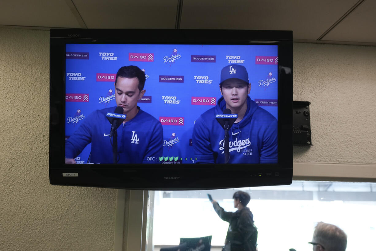 A video screen displays Los Angeles Dodgers' Shohei Ohtani, right, and interpreter Will Ireton during a news conference at Dodger Stadium in Los Angeles, Monday, March 25, 2024. (AP Photo/Jae C.