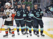 Seattle Kraken right wing Jordan Eberle, right, and center Jaden Schwartz, second from right, head to the bench after Schwartz's goal, as Anaheim Ducks right wing Jakob Silfverberg (33) skates away during the second period of an NHL hockey game Thursday, March 28, 2024, in Seattle.