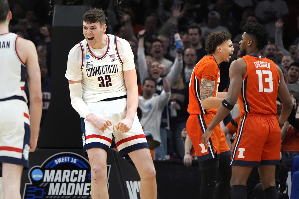 UConn center Donovan Clingan (32) celebrates after his dunk against Illinois during the first half of the Elite 8 college basketball game in the men's NCAA Tournament, Saturday, March 30, 2024, in Boston.