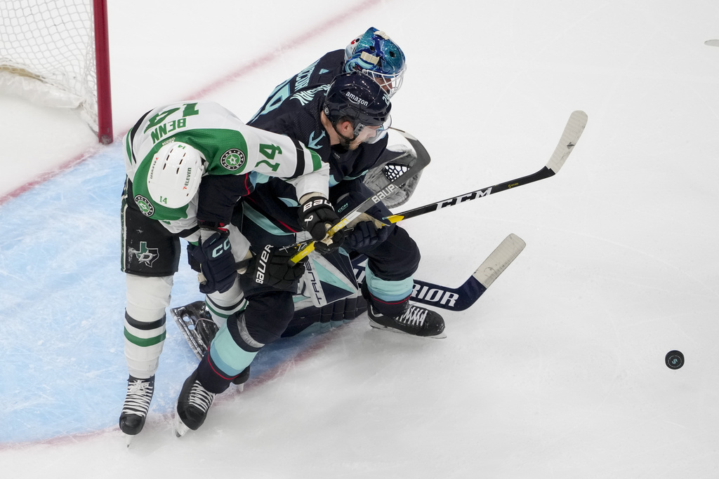 Dallas Stars left wing Jamie Benn, left, is tangled up with Seattle Kraken defenseman Jamie Oleksiak, center, and goaltender Joey Daccord, right, near the Kraken goal during the first period of an NHL hockey game Saturday, March 30, 2024, in Seattle.