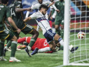 Portland Timbers goalkeeper Maxime Crepeau, back center, watches as Vancouver Whitecaps' Ryan Raposo scores during the second half of an MLS soccer match, in Vancouver, British Columbia, on Saturday, March 30, 2024.