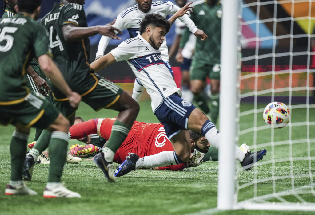 Portland Timbers goalkeeper Maxime Crepeau, back center, watches as Vancouver Whitecaps' Ryan Raposo scores during the second half of an MLS soccer match, in Vancouver, British Columbia, on Saturday, March 30, 2024.
