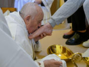 In this image made available by Vatican Media, Pope Francis kisses the foot of a woman inmate of the Rebibbia prison on the outskirts of Rome on Holy Thursday, March 28, 2024, a ritual meant to emphasize his vocation of service and humility. The Holy Thursday foot-washing ceremony is a hallmark of every Holy Week and recalls the foot-washing Jesus performed on his 12 apostles at their last supper together before he was crucified.