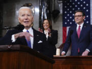 President Joe Biden delivers the State of the Union address to a joint session of Congress at the Capitol, Thursday, March 7, 2024, in Washington. Standing are Vice President Kamala Harris, background center, and House Speaker Mike Johnson, R-La., background right.