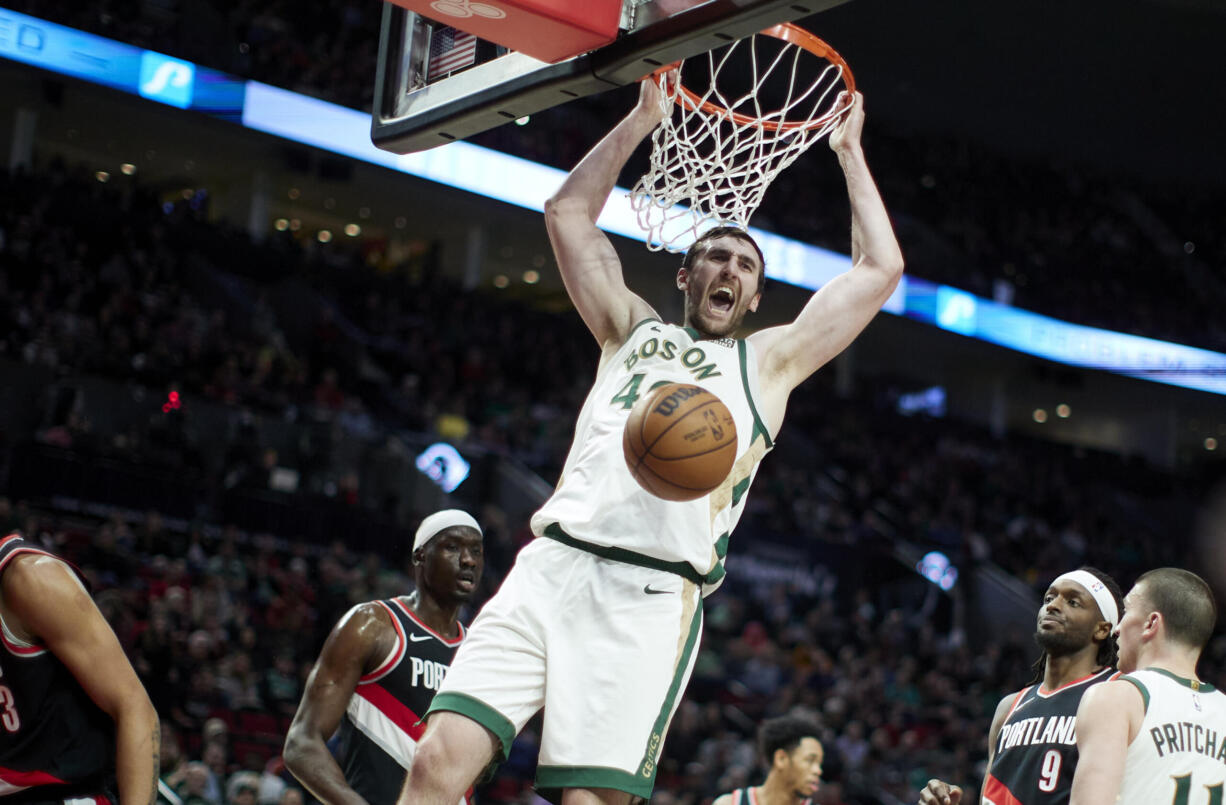 Boston Celtics center Luke Kornet, center, dunks against the Portland Trail Blazers during the first half of an NBA basketball game in Portland, Ore., Monday, March 11, 2024.