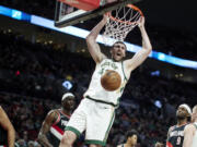 Boston Celtics center Luke Kornet, center, dunks against the Portland Trail Blazers during the first half of an NBA basketball game in Portland, Ore., Monday, March 11, 2024.