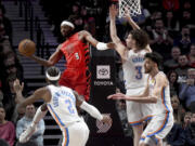 Portland Trail Blazers forward Jerami Grant, second form left, looks to pass the ball as Oklahoma City Thunder guard Shai Gilgeous-Alexander, left, guard Josh Giddey, second from right, and forward Chet Holmgren, right defend during the first half of an NBA basketball game in Portland, Ore., Wednesday, March 6, 2024.