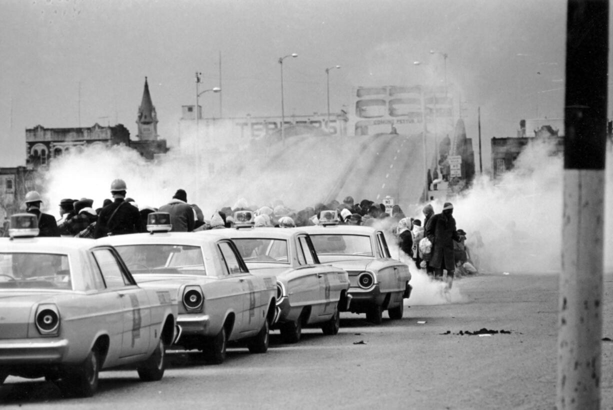 FILE - Tear gas fills the air as state troopers, ordered by Alabama Gov. George Wallace, break up a march at the Edmund Pettus Bridge in Selma, Ala., March 7, 1965, on what became known as Bloody Sunday. Vice President Kamala Harris and Attorney General Merrick Garland are among those marking the 59th anniversary of Bloody Sunday in Selma, Alabama. The events mark law enforcement officers&rsquo; March 7, 1965, attack against demonstrators on the Edmund Pettus Bridge.