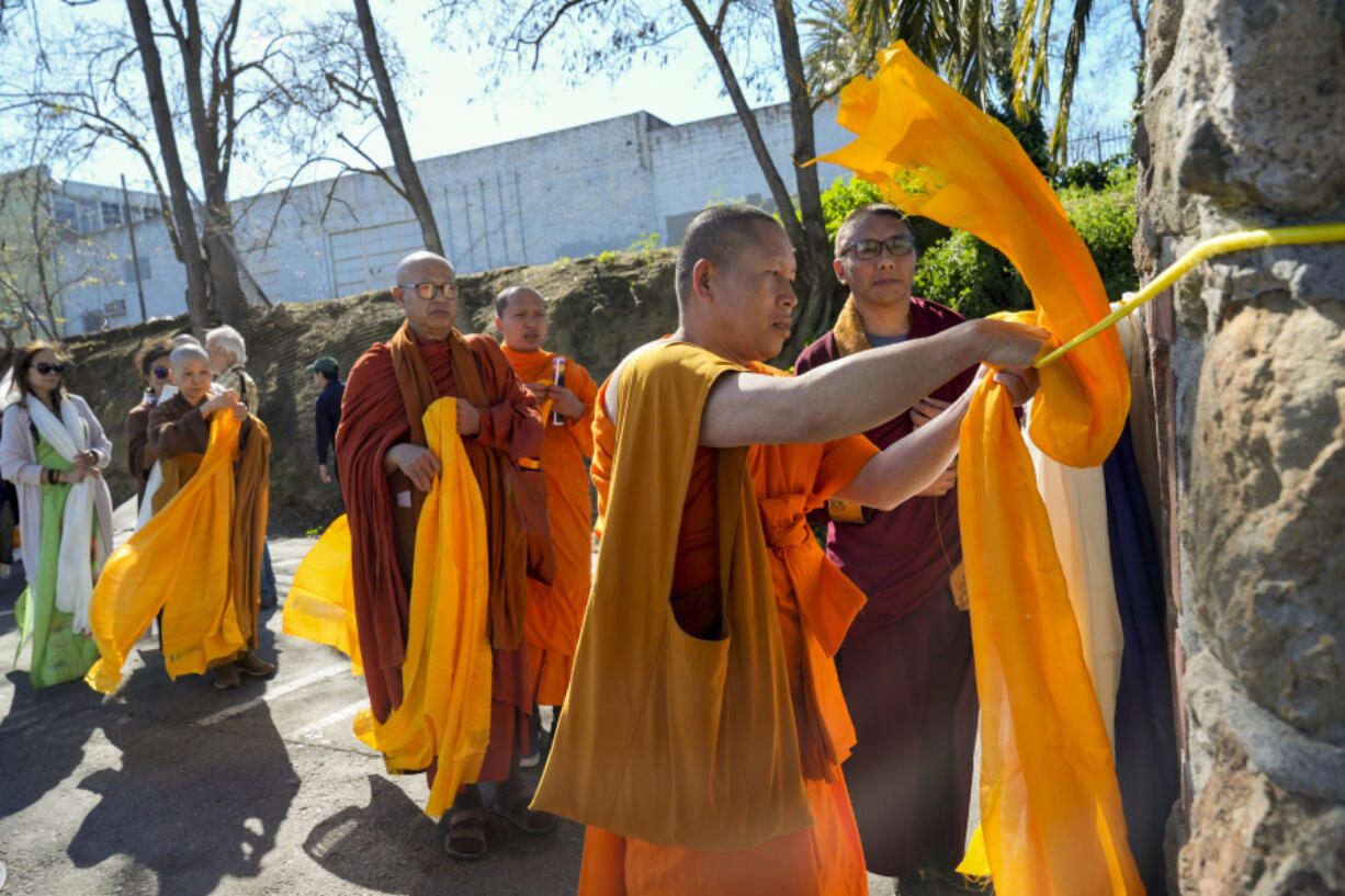 Khammai Sayakoummane, center, places a Tibetan scarf on the Birthplace of Antioch marker March 16 during the &ldquo;May We Gather&rdquo; pilgrimage in Antioch, Calif. The event aimed to use karmic cleansing through chants, prayer and testimony to heal racial trauma caused by anti-Chinese discrimination in Antioch in the 1870s. (Godofredo A.