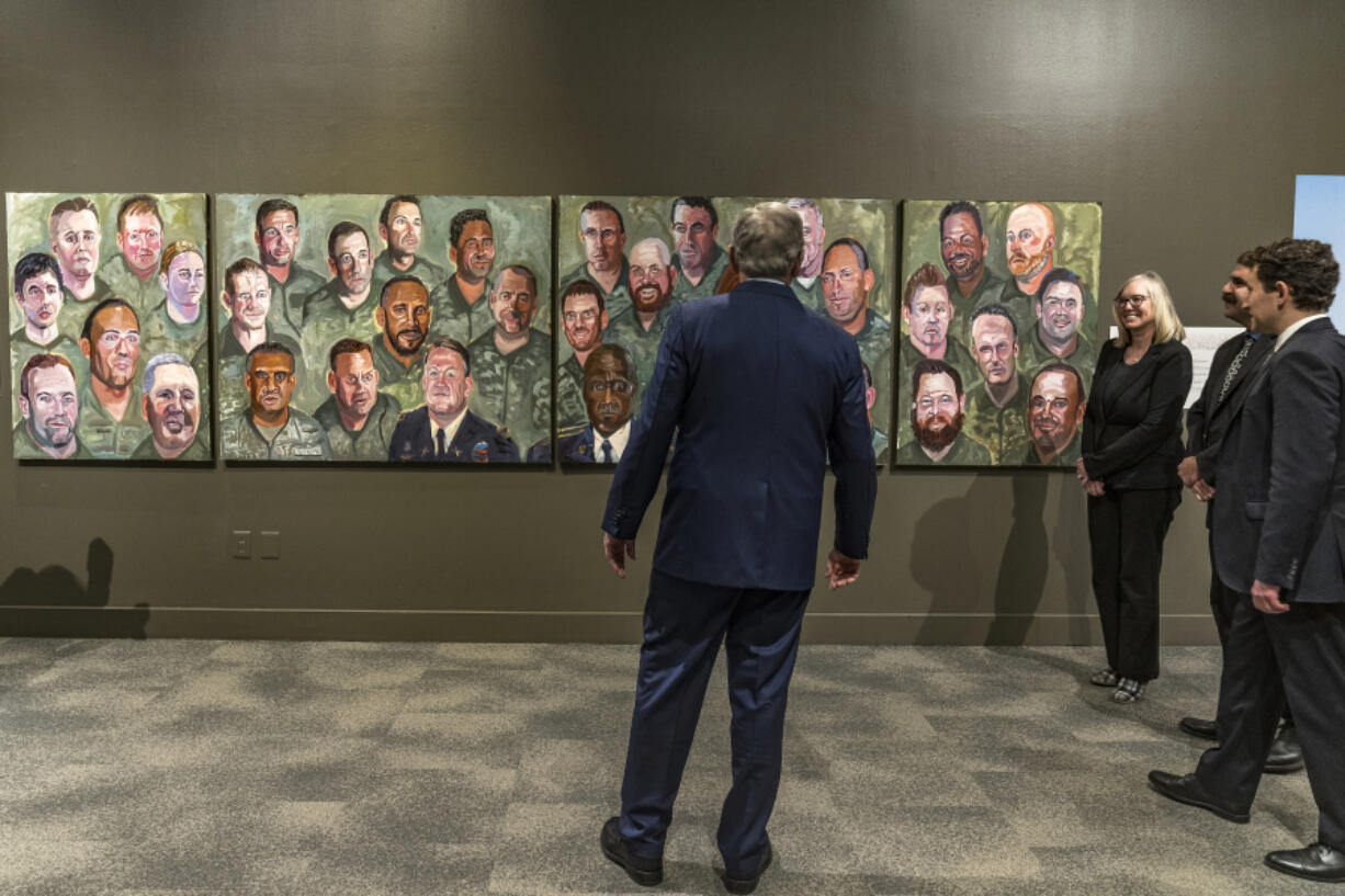 Former President George W. Bush looks at his paintings Wednesday, as he is greeted by curators, Christine Mickey and Jason Schwartz, as he tours an exhibit of his paintings of military veterans at the Richard Nixon Presidential Library and Museum in Yorba Linda, Calif. Jim Byron, Elected President and CEO of the Nixon Foundation joins them at far right. The exhibit &ldquo;Portraits of Courage: A Commander in Chief&rsquo;s Tribute to America&rsquo;s Warriors&rdquo; is displayed for the first time on the West Coast.