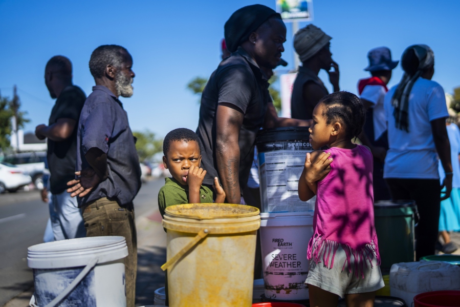 Residents of the township of Soweto, South Africa, queue for water March 16.