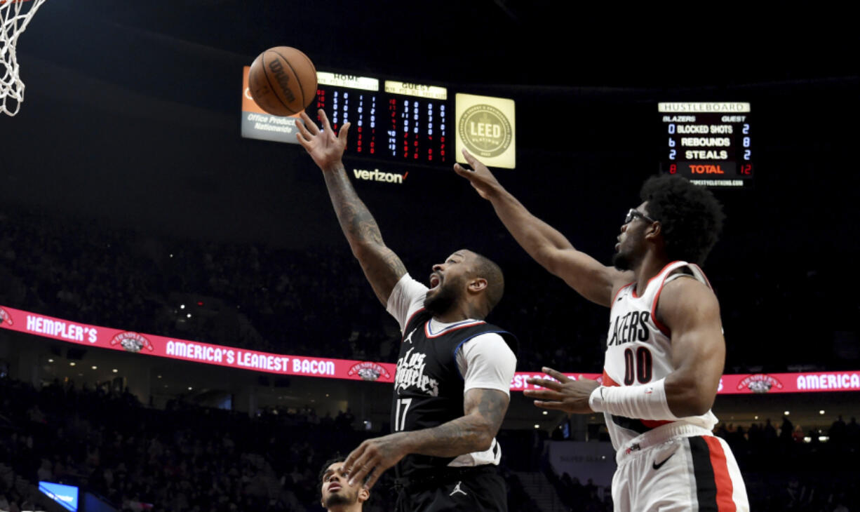Los Angeles Clippers forward P.J. Tucker, left shoots the ball over Portland Trail Blazers guard Scoot Henderson, right, during the first half of an NBA basketball game in Portland, Ore., Friday, March 22, 2024.